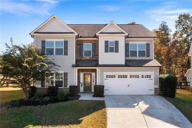 a front view of a house with a yard and a garage