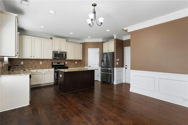 a kitchen with granite countertop white cabinets and stainless steel appliances