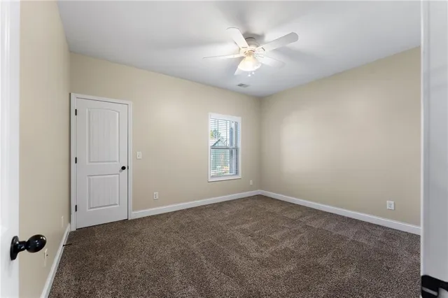 a view of an empty room with a chandelier fan