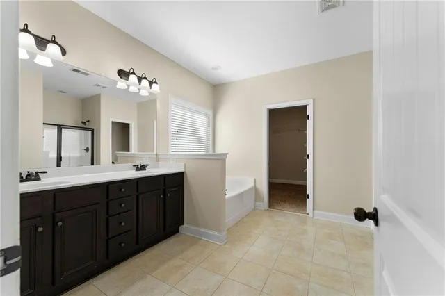 a spacious bathroom with a double vanity sink a mirror and a shower