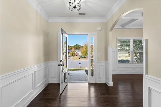a view of a hallway with wooden floor and a cabinet