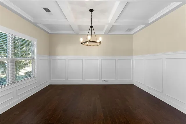 a view of a room with wooden floor exposed radiator and a window