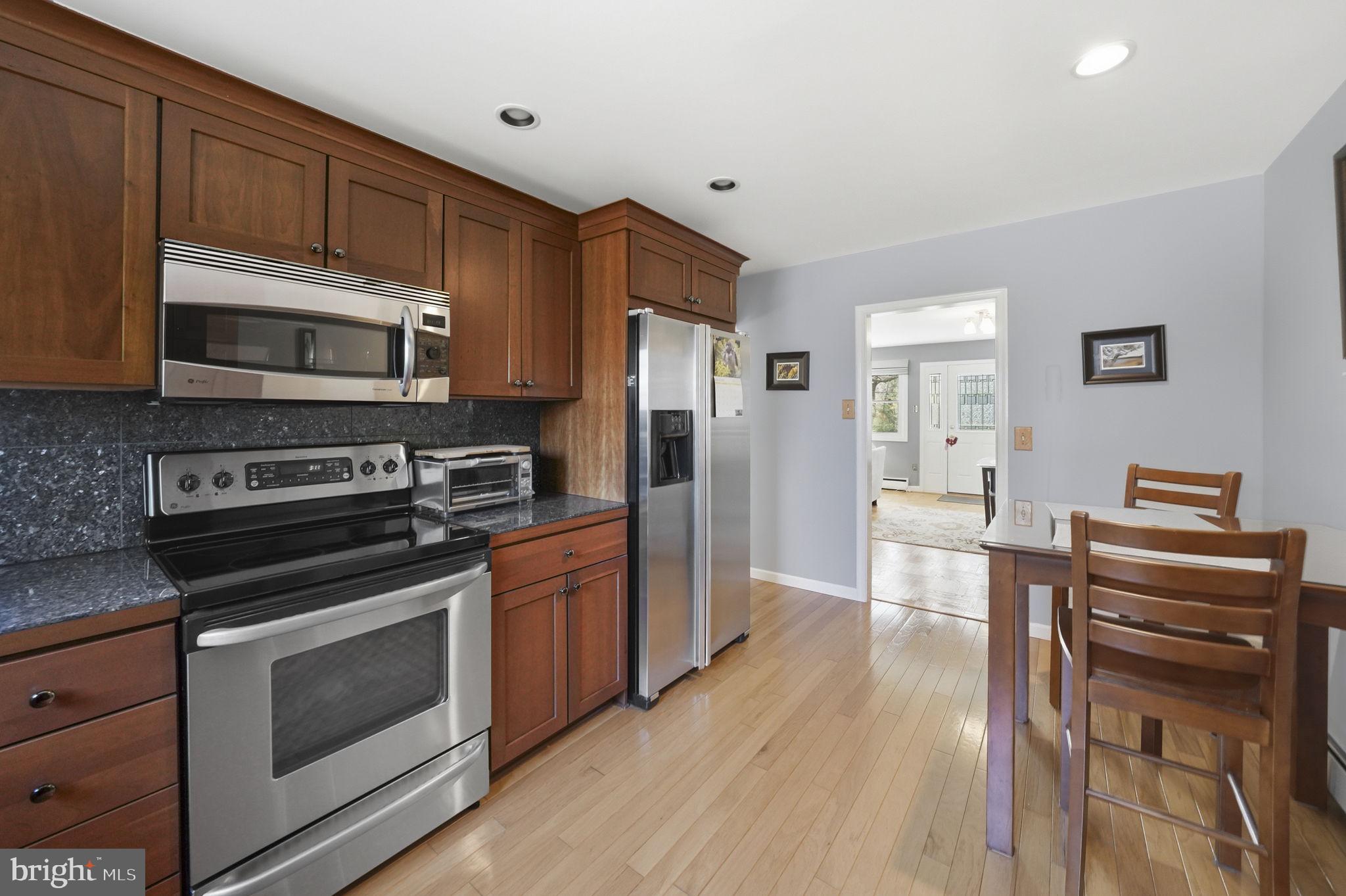28 Green Ridge Road Yardley, PA 19067 - Photo 15 of 49 a kitchen with granite countertop wooden cabinets stainless steel appliances and wooden floor