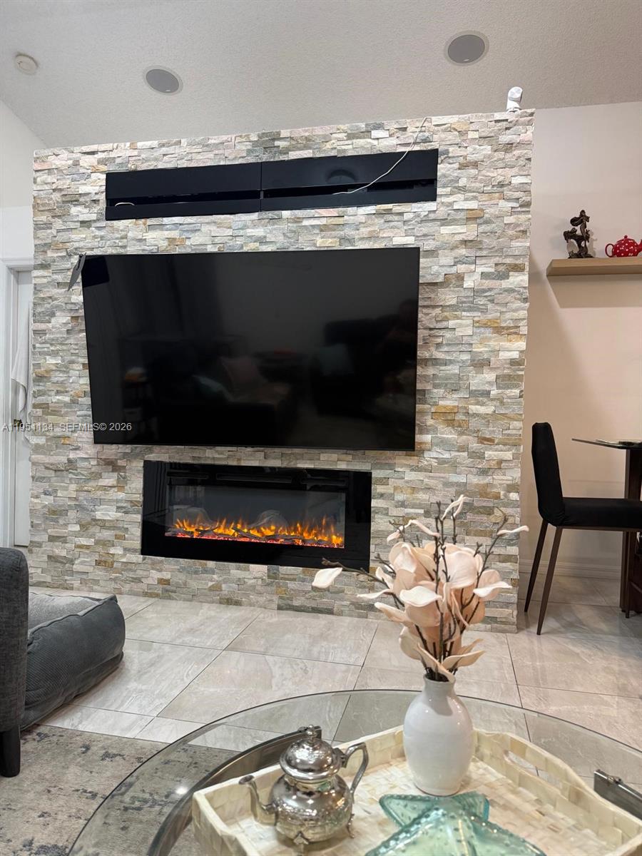 1308 Alexander Bend Weston, FL 33327 - Photo 11 of 54 a living room with furniture a flat screen tv and a fireplace