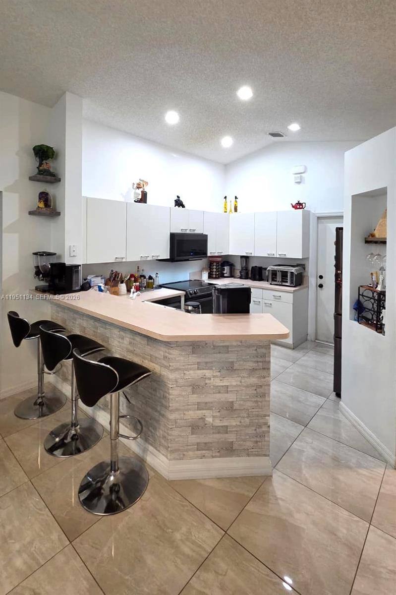 1308 Alexander Bend Weston, FL 33327 - Photo 12 of 54 a kitchen with a counter top cabinets and appliances