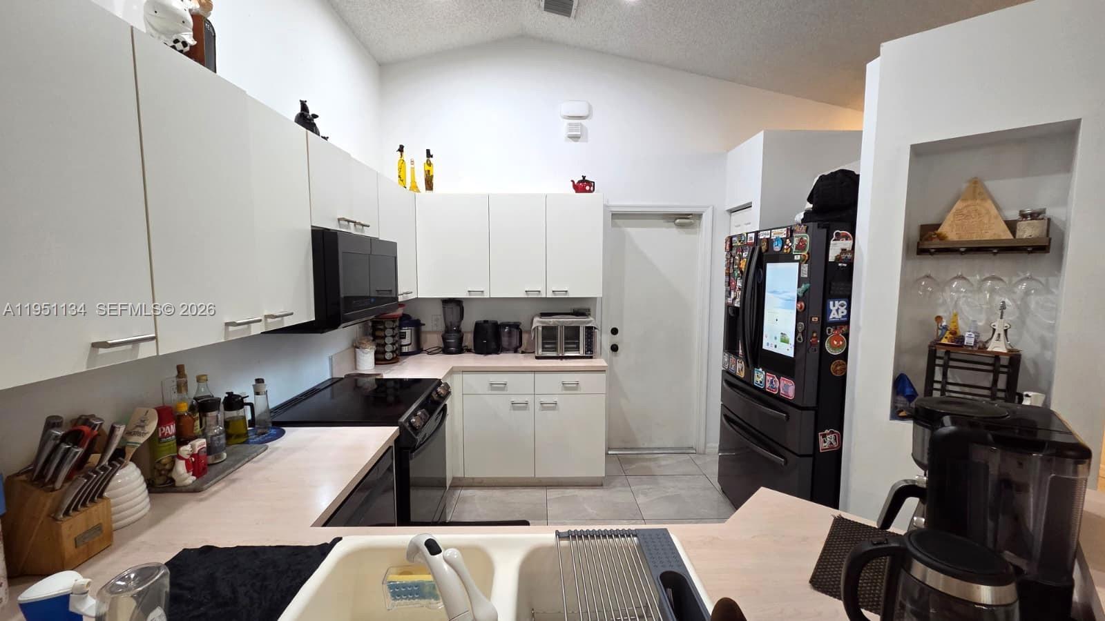 1308 Alexander Bend Weston, FL 33327 - Photo 13 of 54 a kitchen with a sink appliances and cabinets