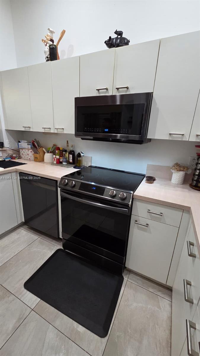 1308 Alexander Bend Weston, FL 33327 - Photo 14 of 54 a kitchen with a stove and a microwave