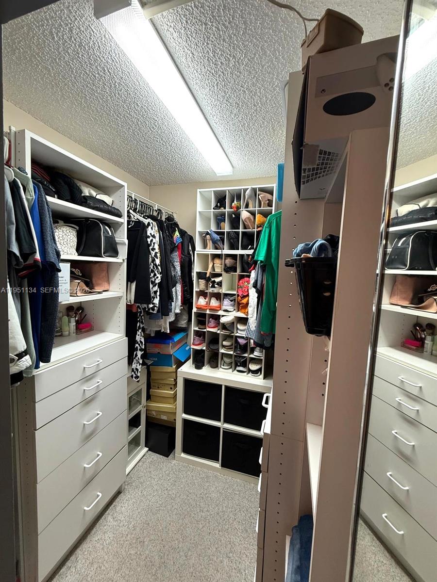 1308 Alexander Bend Weston, FL 33327 - Photo 18 of 54 a view of walk in closet with clothes and shoes