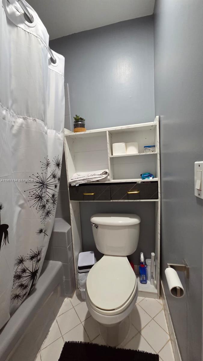 1308 Alexander Bend Weston, FL 33327 - Photo 20 of 54 a bathroom with a toilet and a shower curtain