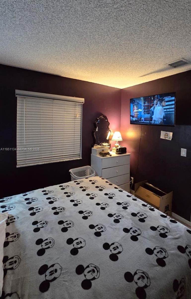 1308 Alexander Bend Weston, FL 33327 - Photo 23 of 54 a bedroom with a bed and a dresser