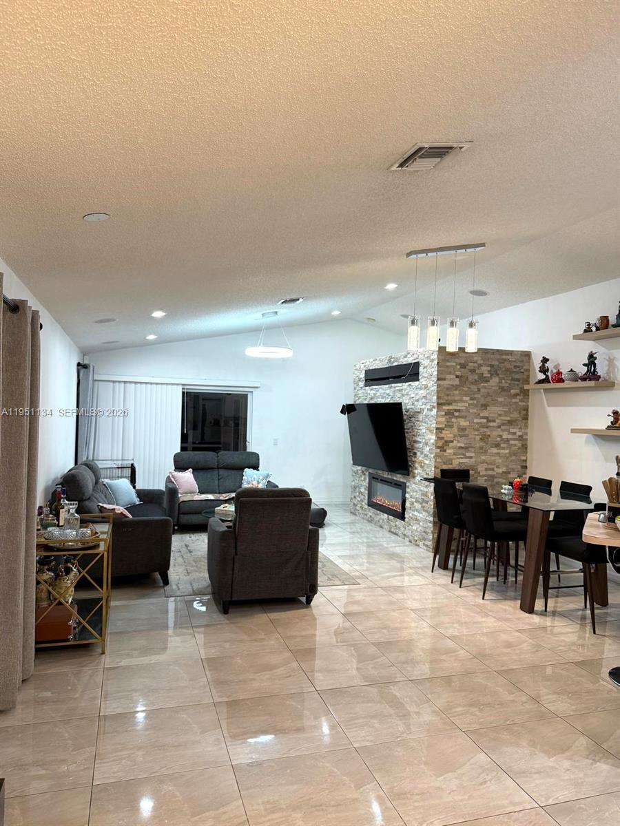 1308 Alexander Bend Weston, FL 33327 - Photo 7 of 54 a living room with furniture a flat screen tv and a fireplace