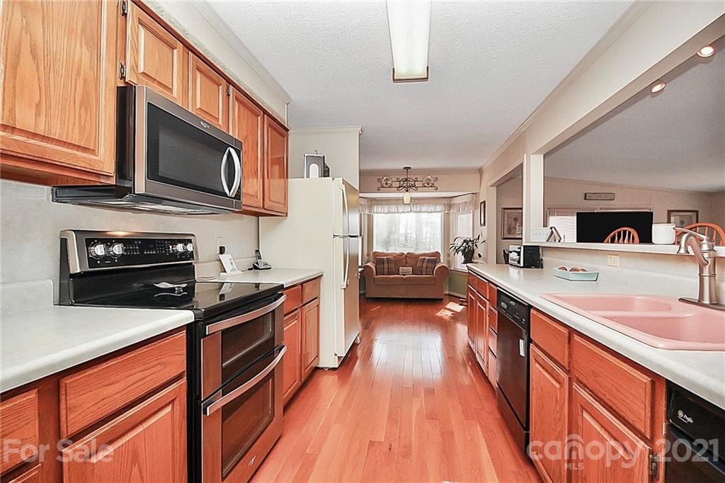 29032 Snapper Point Tega Cay, SC 29708 - Photo 11 of 48 a kitchen with stainless steel appliances kitchen island granite countertop a stove a sink and a microwave