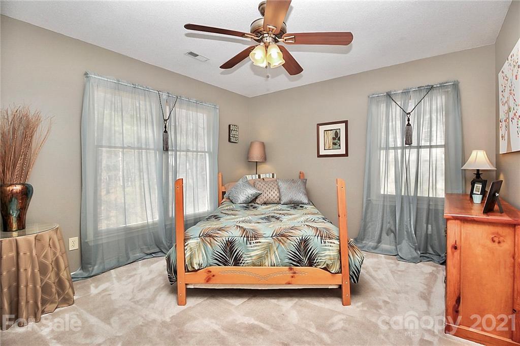 29032 Snapper Point Tega Cay, SC 29708 - Photo 24 of 48 a bedroom with a bed and a chandelier
