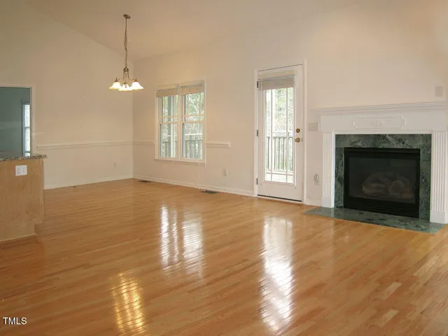 a view of an empty room with glass door and wooden floor