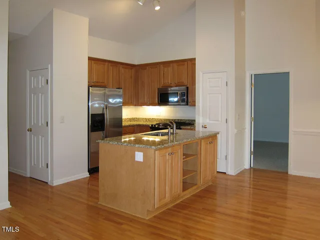 a kitchen with stainless steel appliances a stove top oven a sink and a refrigerator