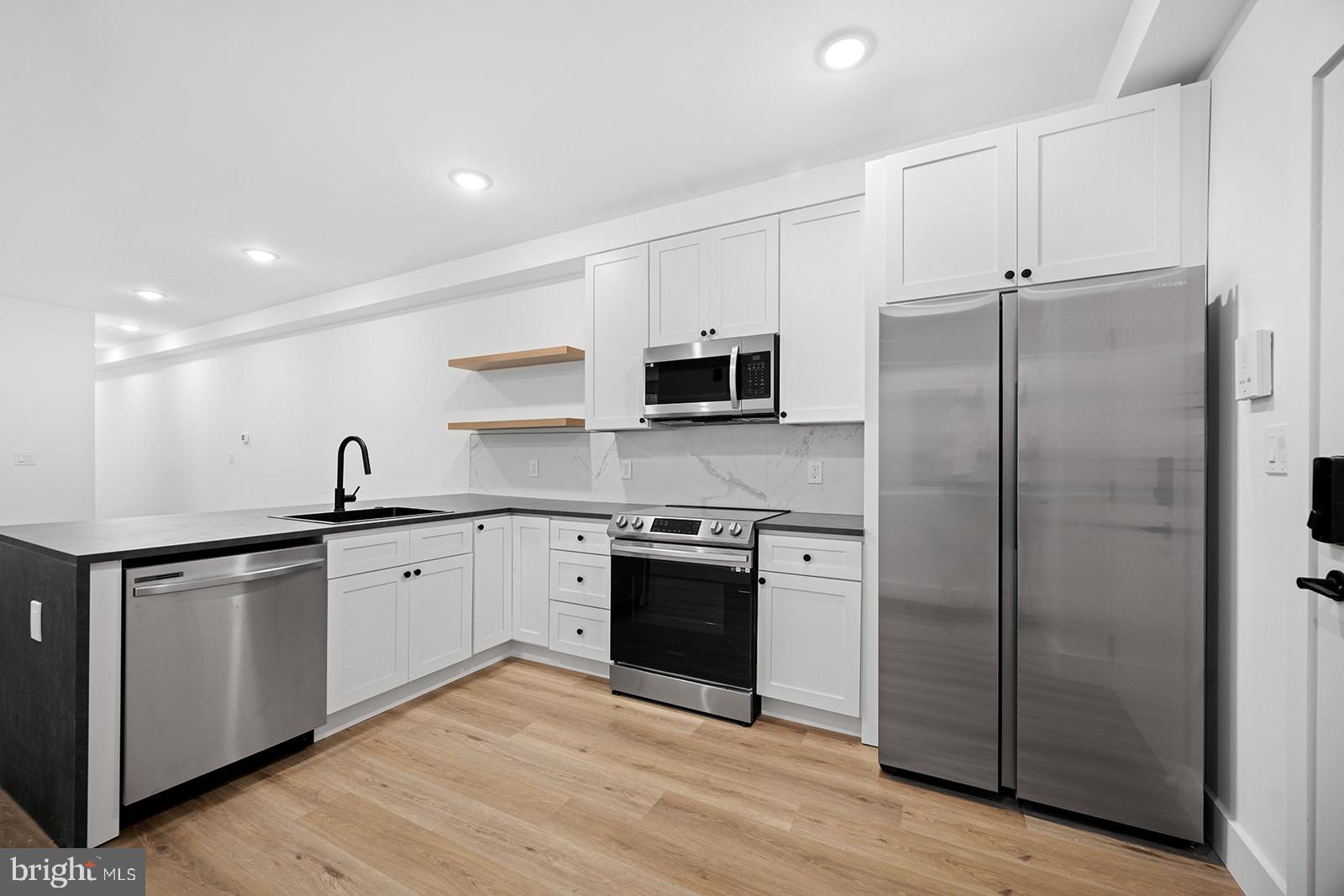 a kitchen with stainless steel appliances granite countertop a refrigerator and a sink