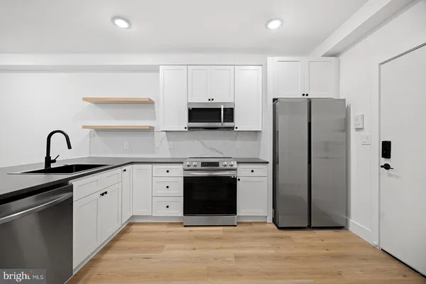 a kitchen with stainless steel appliances granite countertop a refrigerator sink and stove