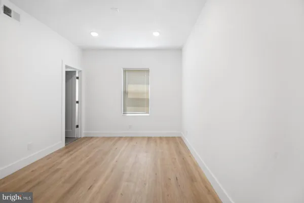 an empty room with wooden floor and a window