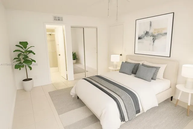 a bedroom with bed and a painting on the wall