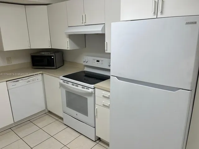 a view of a kitchen with white cabinets