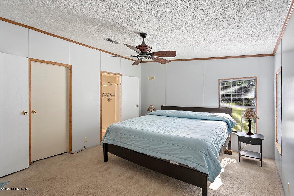2987 Green Acres Road St. Augustine, FL 32084 - Photo 15 of 31 a bedroom with a bed and a table