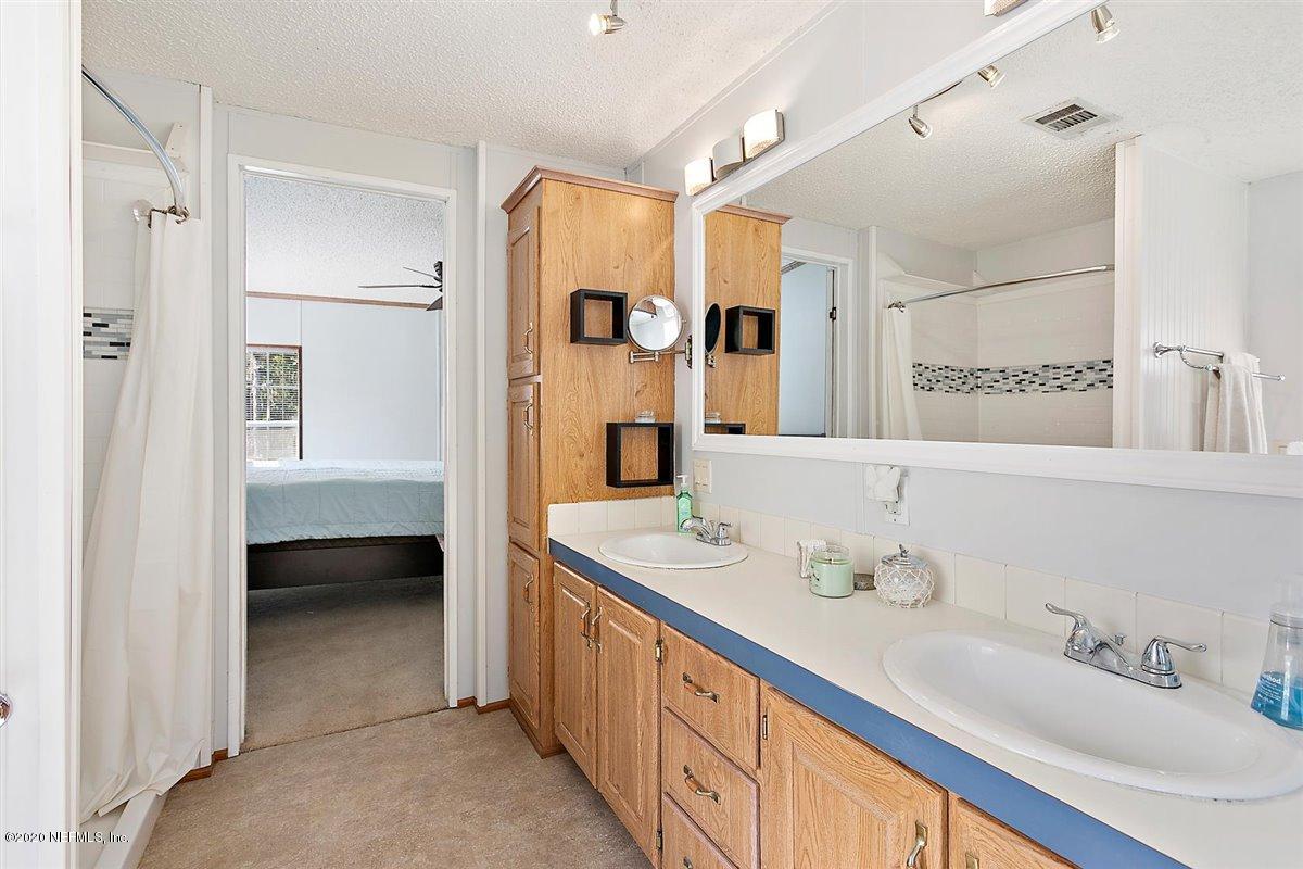 2987 Green Acres Road St. Augustine, FL 32084 - Photo 17 of 31 a bathroom with a double vanity sink mirror and double