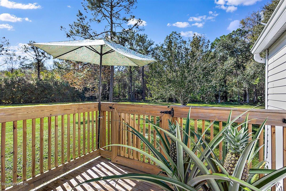 2987 Green Acres Road St. Augustine, FL 32084 - Photo 8 of 31 a view of a balcony with wooden floor and umbrella