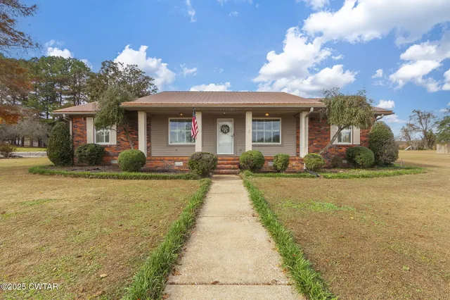 a front view of house with yard and trees around
