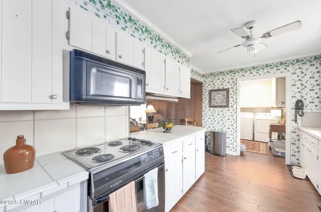 a kitchen with a stove a sink and a microwave