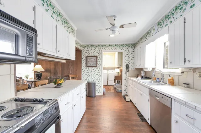 a kitchen with stainless steel appliances a sink stove and cabinets