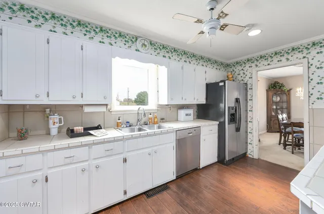 a kitchen with a sink dishwasher white cabinets and refrigerator