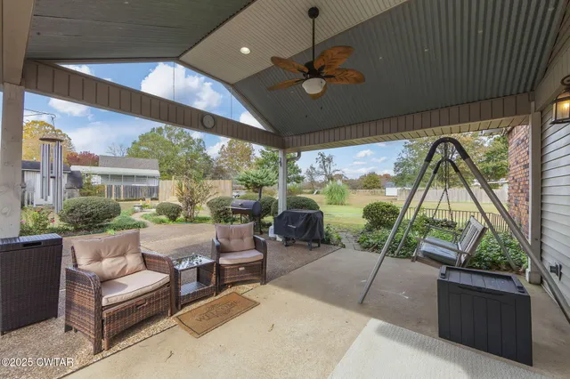 a living room with patio furniture and a floor to ceiling window