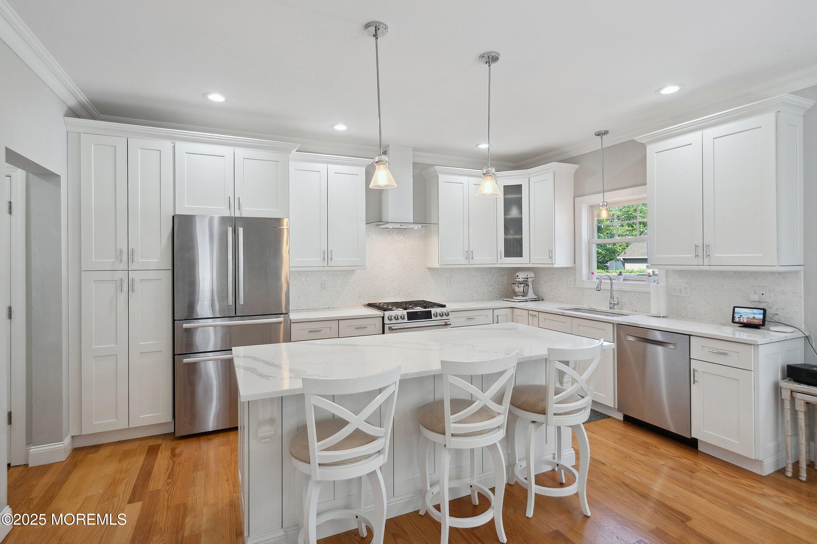 309 Hall Avenue Point Pleasant, NJ 08742 - Photo 5 of 35 a kitchen with stainless steel appliances granite countertop a refrigerator a sink dishwasher a stove and white cabinets with wooden floor