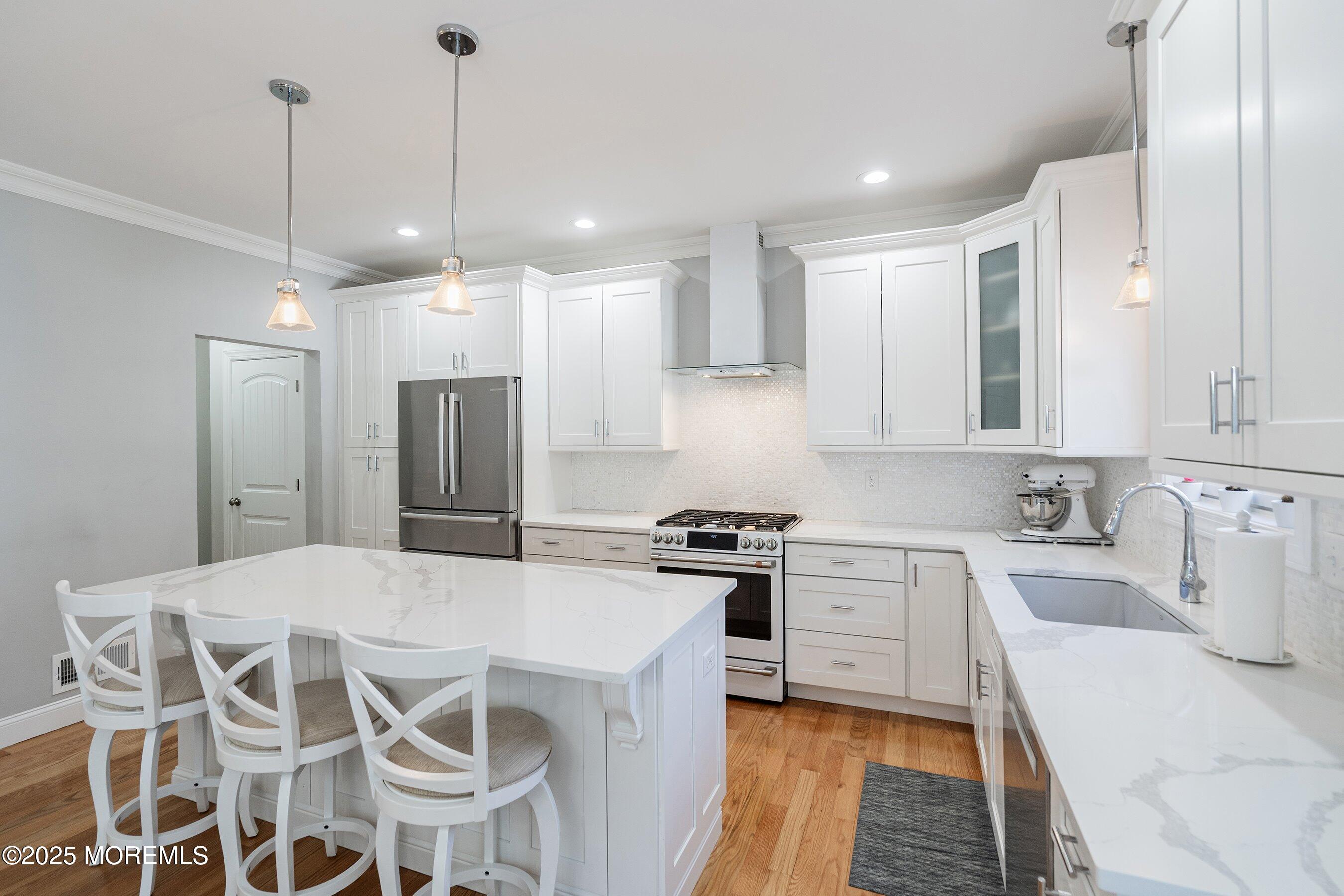 309 Hall Avenue Point Pleasant, NJ 08742 - Photo 6 of 35 a kitchen with stainless steel appliances kitchen island granite countertop a sink a stove a refrigerator and island with wooden floor