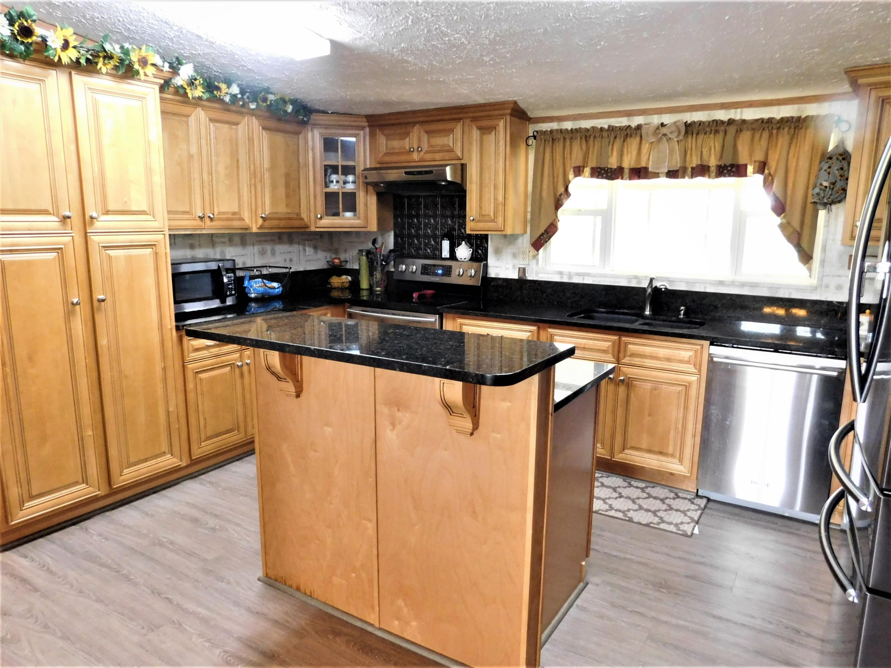 a kitchen with stainless steel appliances granite countertop a stove a sink and a microwave