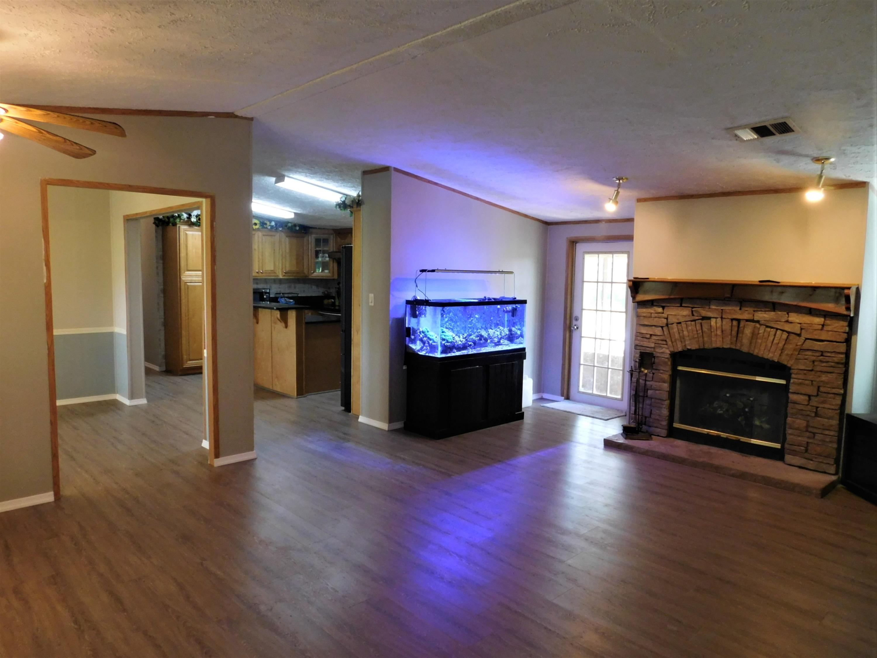 1533 Messick Road Baker, FL 32531 - Photo 21 of 40 a living room with a fireplace a flat screen tv and a fireplace