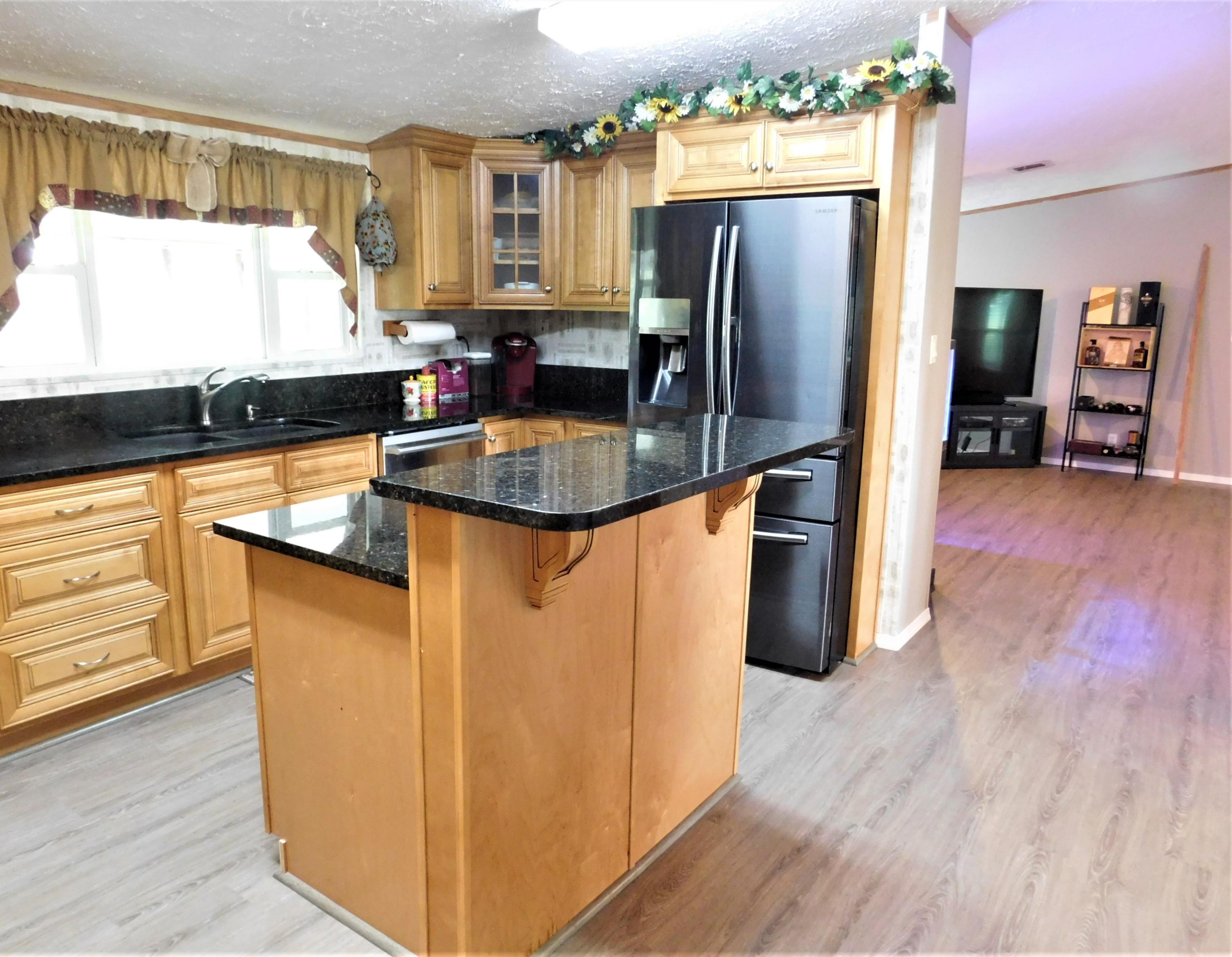 1533 Messick Road Baker, FL 32531 - Photo 22 of 40 a kitchen with stainless steel appliances granite countertop a refrigerator a stove and a wooden floors