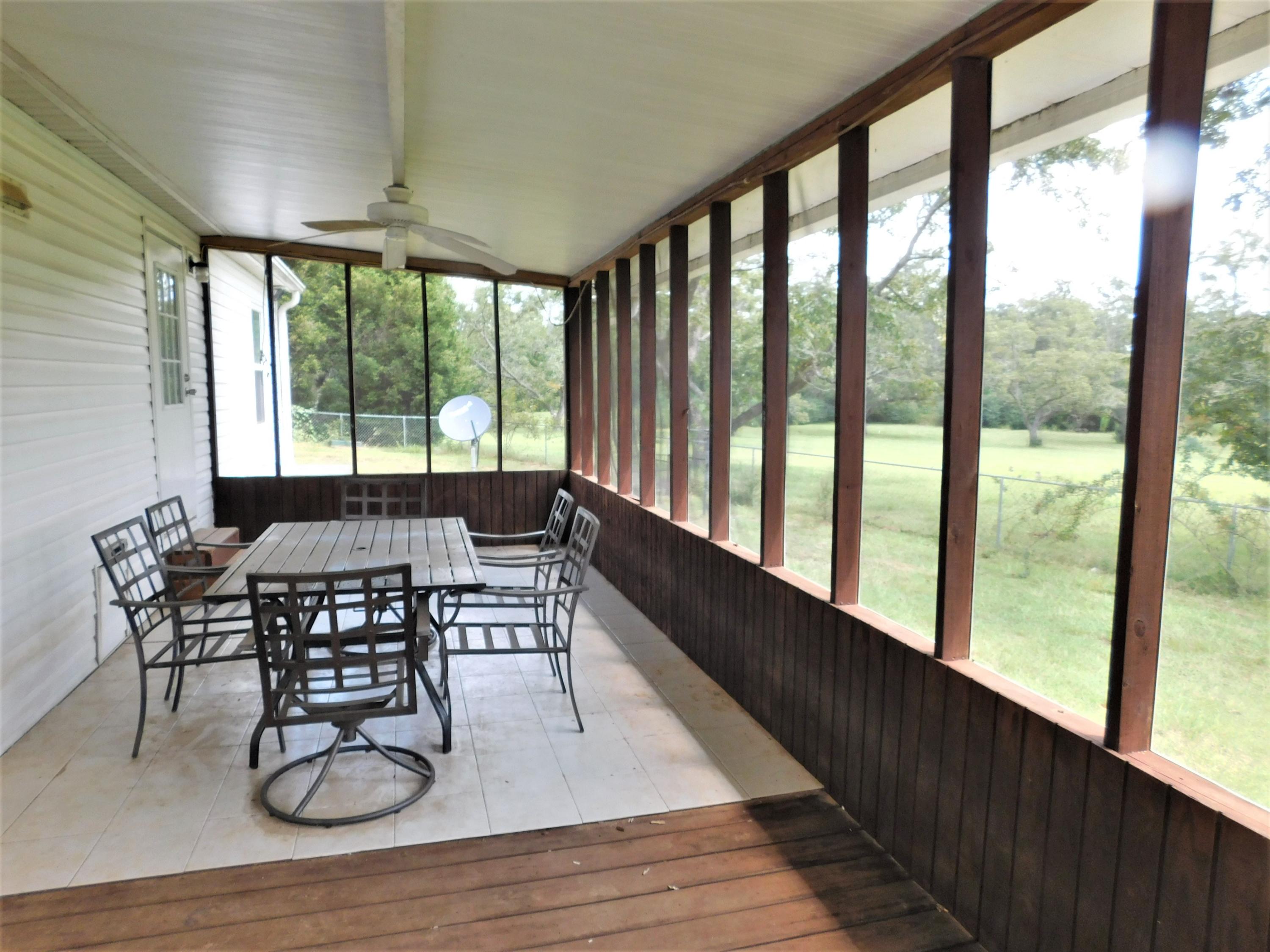 1533 Messick Road Baker, FL 32531 - Photo 23 of 40 a dining room with wooden floor a glass table and chairs