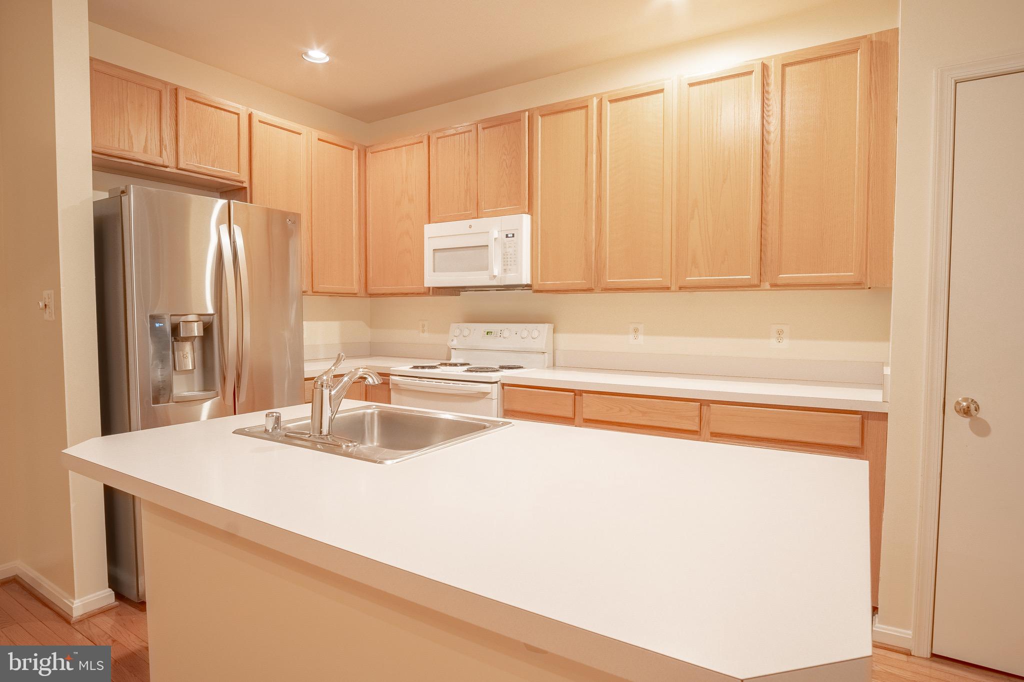 104 Penwick Circle Frederick, MD 21702 - Photo 8 of 24 a kitchen with a sink cabinets and a refrigerator