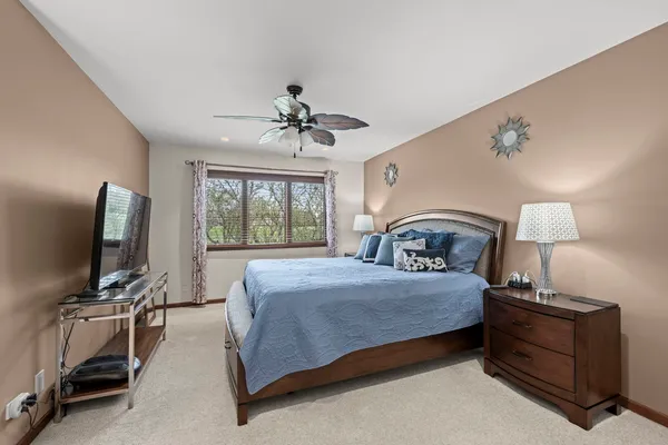 a bedroom with a large bed and a flat tv screen on dresser