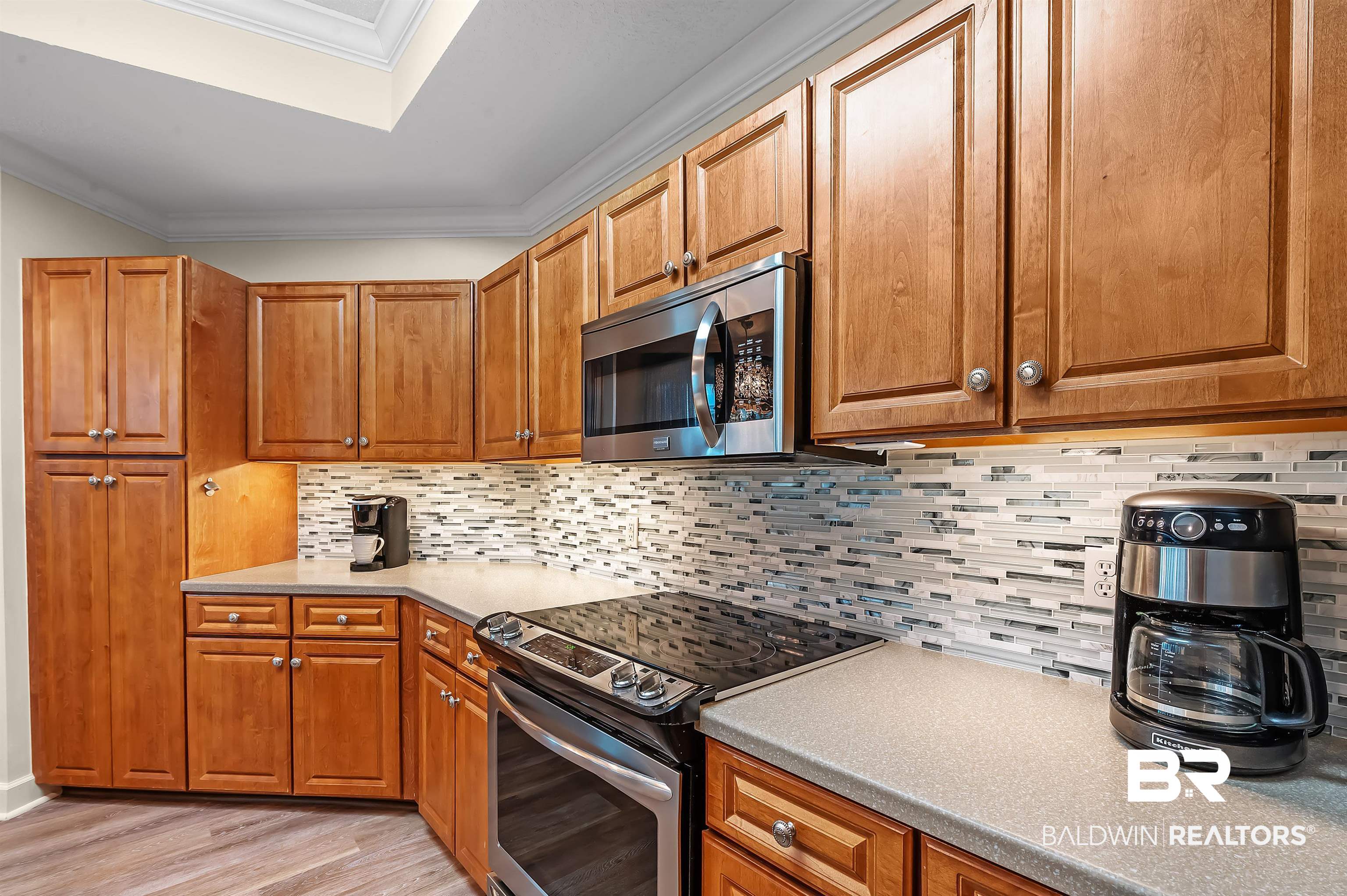 27582 Canal Road, Unit 2104 Orange Beach, AL 36561 - Photo 14 of 35 Kitchen with ornamental molding, stainless steel appliances, light hardwood / wood-style floors, and tasteful backsplash