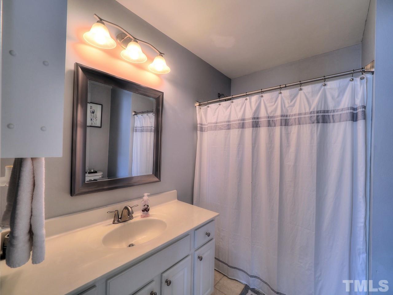 7250 Galon Glen Road Raleigh, NC 27613 - Photo 22 of 27 a bathroom with a sink and a mirror