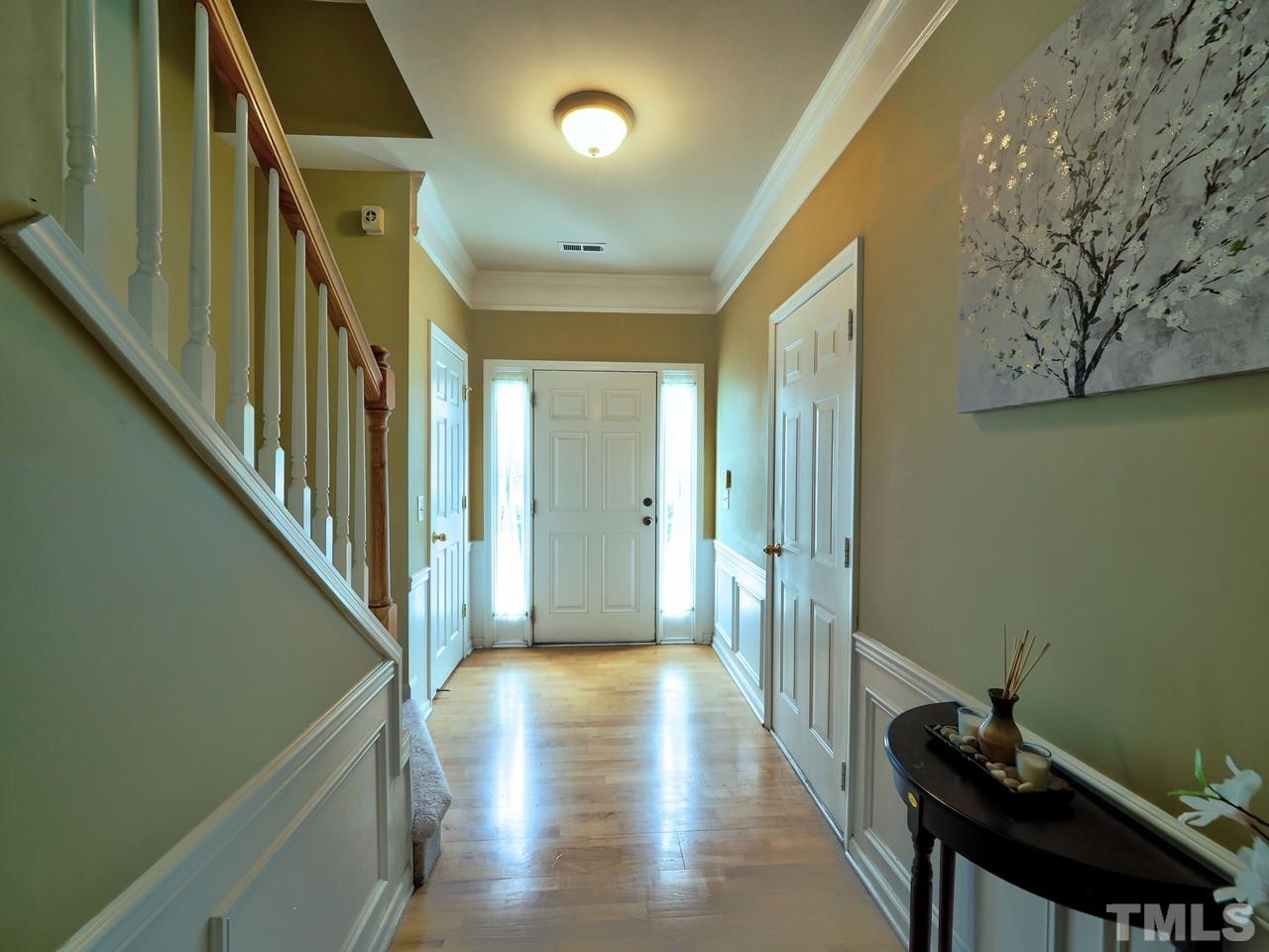 7250 Galon Glen Road Raleigh, NC 27613 - Photo 4 of 27 a view of a hallway with wooden floor and staircase