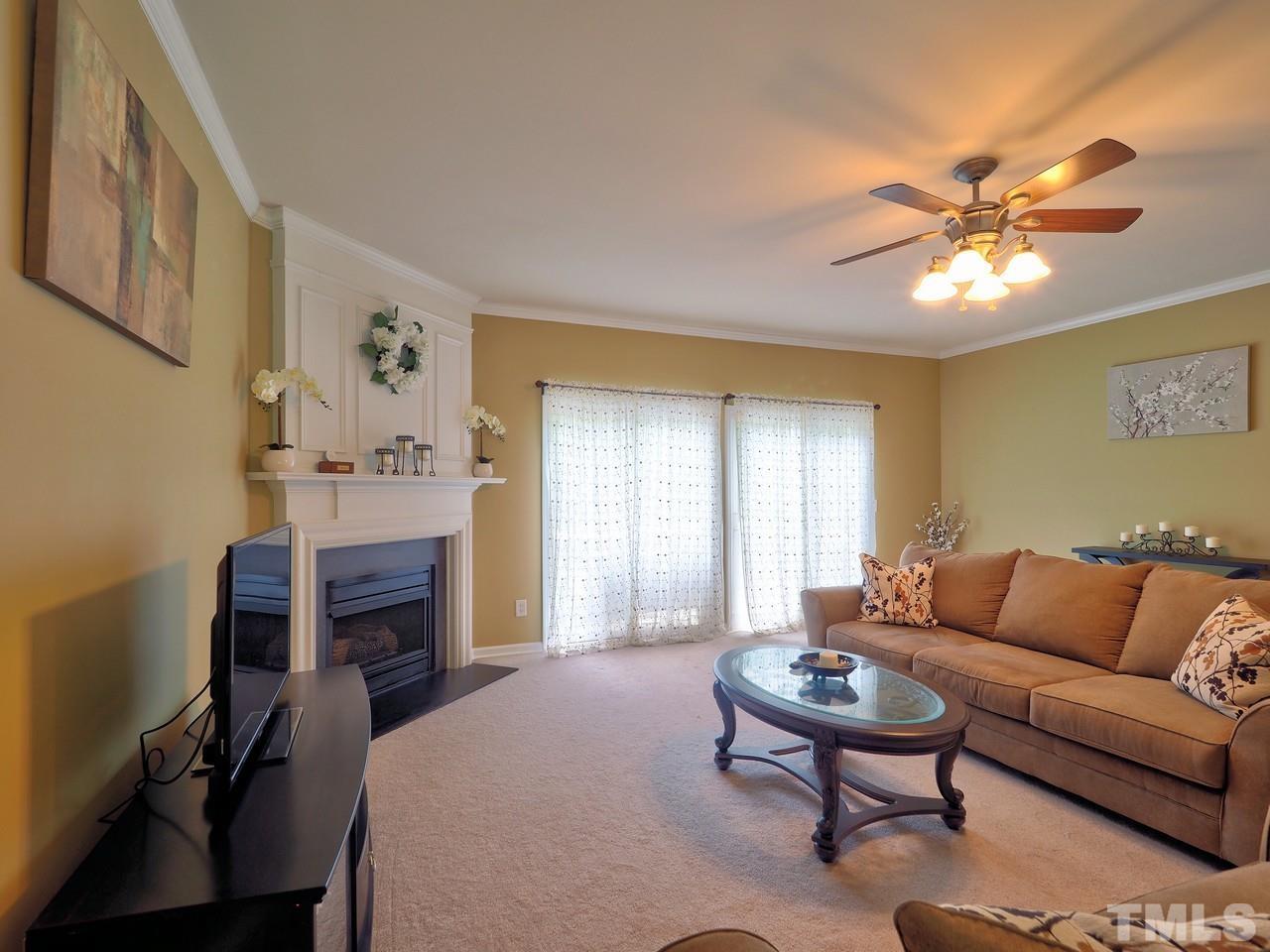 7250 Galon Glen Road Raleigh, NC 27613 - Photo 7 of 27 a living room with furniture a fireplace and a window