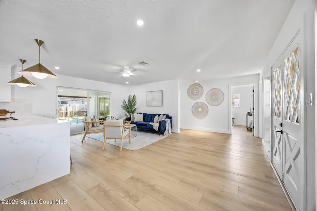 a view of a livingroom with furniture hardwood floor and a ceiling fan