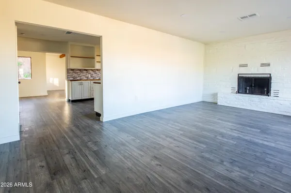 a view of a hallway with wooden floor and a fireplace