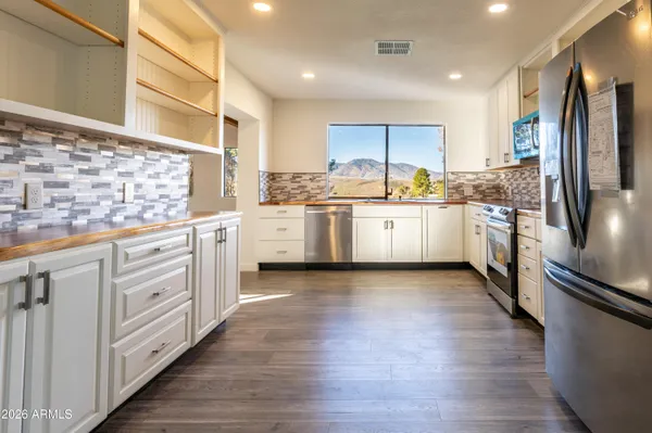 a kitchen with stainless steel appliances a stove refrigerator sink and cabinets