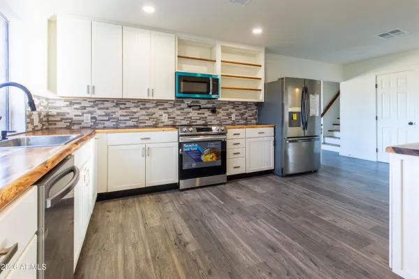a kitchen with stainless steel appliances granite countertop a stove a sink and a refrigerator