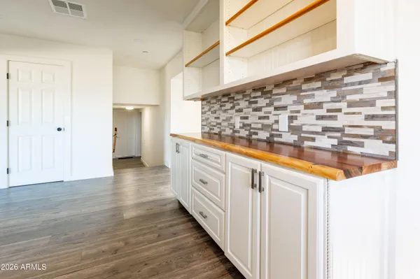 a kitchen with granite countertop white cabinets and wooden floor