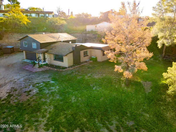 an aerial view of residential houses with outdoor space and trees